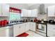 Kitchen featuring stainless steel appliances, white cabinets, black countertop, and decorative backsplash at 511 E Mirror Lake Dr, Fruitland Park, FL 34731