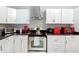 Well-lit kitchen with stainless steel appliances, white cabinets, dark countertops, and a decorative backsplash at 511 E Mirror Lake Dr, Fruitland Park, FL 34731