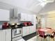 Spacious kitchen with white cabinets, modern appliances, dark counters, and a red retro dining table at 511 E Mirror Lake Dr, Fruitland Park, FL 34731