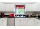Updated kitchen boasts white cabinets, modern appliances, dark counters, and decorative backsplash at 511 E Mirror Lake Dr, Fruitland Park, FL 34731