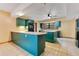 Open kitchen with island, tiled floor, and plenty of natural light at 5180 Garlanger Trl, Oviedo, FL 32765