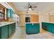 Spacious kitchen with tile flooring, center island, ceiling fan, and turquoise cabinets at 5180 Garlanger Trl, Oviedo, FL 32765