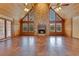 Open living room with a stone fireplace, wood-paneled walls and ceilings, and lots of natural light at 5180 Garlanger Trl, Oviedo, FL 32765