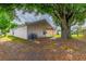 A shot of the spacious backyard featuring mature trees and covered patio at 5423 Blueberry Dr, Orlando, FL 32811