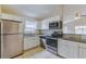 Well-equipped kitchen featuring stainless steel appliances, white cabinetry, and granite countertops at 5423 Blueberry Dr, Orlando, FL 32811