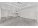 Expansive living room features gray wood floors and flows into the modern kitchen with white cabinets at 5438 Brownell St, Orlando, FL 32810
