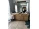 Bathroom vanity with a large mirror, double sinks, ample counter space, and tiled floor for convenience at 567 Queensbridge Dr, Lake Mary, FL 32746