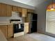 Functional kitchen with light oak cabinets, black appliances, and tiled floors at 567 Queensbridge Dr, Lake Mary, FL 32746