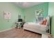 Comfortable bedroom painted in a light green hue featuring a well-lit window at 595 American Holly Pl, Oviedo, FL 32765