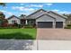 Inviting single-Gathering home featuring a three-car garage and beautifully landscaped front yard at 595 American Holly Pl, Oviedo, FL 32765