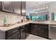 A kitchen with dark wood cabinets, stainless steel appliances, and granite countertops at 595 American Holly Pl, Oviedo, FL 32765