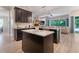 Kitchen with dark cabinets, an island, and a view of the living room at 595 American Holly Pl, Oviedo, FL 32765