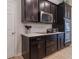 Modern kitchen features sleek dark cabinetry, stainless steel appliances, and stylish backsplash at 595 American Holly Pl, Oviedo, FL 32765