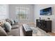 Inviting living room with a modern television, stylish cabinet, and cozy seating area at 595 American Holly Pl, Oviedo, FL 32765