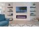 Stylish living room features modern fireplace and TV, floating shelves, and a comfortable armchair at 595 American Holly Pl, Oviedo, FL 32765