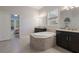 Spacious main bathroom with a large soaking tub, granite counters, and private access to the bedroom at 595 American Holly Pl, Oviedo, FL 32765