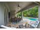 Inviting covered patio boasts ample seating, ceiling fans, and a serene view of the sparkling pool and lush greenery at 595 American Holly Pl, Oviedo, FL 32765