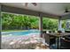 Covered patio and pool featuring an outdoor dining set and lush backyard landscaping at 595 American Holly Pl, Oviedo, FL 32765