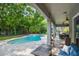 Backyard view featuring a beautiful pool with an attached spa, patio, and lush greenery at 595 American Holly Pl, Oviedo, FL 32765