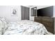 Comfortable bedroom with a tropical-patterned bedspread, TV, and a framed modern art picture at 6543 Orange Cream Aly, Winter Garden, FL 34787