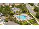 Aerial view of a community pool with palm trees, lounge chairs, and a clubhouse in a well-maintained neighborhood at 6543 Orange Cream Aly, Winter Garden, FL 34787