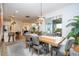 Open-concept dining area with a wooden table, gray chairs, and a view of the kitchen and backyard at 6543 Orange Cream Aly, Winter Garden, FL 34787