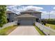 Exterior view of a home showing the garage, a fenced yard and a patio with a table at 6543 Orange Cream Aly, Winter Garden, FL 34787
