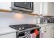 Close-up of a modern gas cooktop set in a bright kitchen with white cabinets and subway tile backsplash at 6543 Orange Cream Aly, Winter Garden, FL 34787