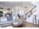 Cozy living room with a comfortable sofa, stylish decor, and a staircase leading to the upper level at 6543 Orange Cream Aly, Winter Garden, FL 34787