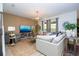 Comfortable living room with a plush sofa, large TV, and bright windows offering plenty of natural light at 6543 Orange Cream Aly, Winter Garden, FL 34787
