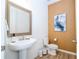 Neat half bathroom featuring a pedestal sink, toilet, and a framed mirror above the sink at 6543 Orange Cream Aly, Winter Garden, FL 34787