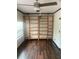 Bedroom featuring dark wood floors, a fan, a projector, and large shelving for storage at 701 Twin Lake Ave, Deltona, FL 32738