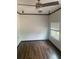 Bedroom featuring dark hardwood floors, white walls, and a ceiling fan with lighting at 701 Twin Lake Ave, Deltona, FL 32738