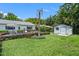 Spacious backyard with a well-manicured lawn, mature trees, a shed, and an outdoor hot tub at 711 Valencia Ct, Winter Garden, FL 34787