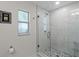 Updated bathroom featuring a glass shower with pebble floor, tile walls, and updated hardware at 711 Valencia Ct, Winter Garden, FL 34787