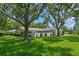 Attractive home with a large, green front yard, mature trees, and a welcoming facade at 711 Valencia Ct, Winter Garden, FL 34787