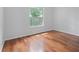 This bedroom features gleaming hardwood floors and a large window overlooking the backyard at 7698 Mount Carmel Dr, Orlando, FL 32835