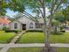 Charming single-story home featuring a well-manicured lawn, lush landscaping, and a distinctive tiled roof at 7698 Mount Carmel Dr, Orlando, FL 32835