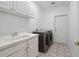 Functional laundry room with sink, cabinets, and modern washer and dryer at 7698 Mount Carmel Dr, Orlando, FL 32835