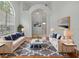 Sunlit living room featuring hardwood floors, neutral furniture, and views of the yard through large windows at 7698 Mount Carmel Dr, Orlando, FL 32835