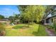 Lush backyard with green grass, mature trees, and a play set at 814 Jefferson Ave, Lakeland, FL 33801