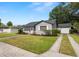 Well-maintained home with a driveway leading to a garage and a sidewalk to a pink front door with beautiful lawn at 814 Jefferson Ave, Lakeland, FL 33801