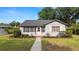 Charming single story home with gray paint, a pink front door and lush landscaping in the front yard at 814 Jefferson Ave, Lakeland, FL 33801