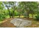 Serene backyard space with a concrete slab, seating, mature trees, and bridge feature, perfect for outdoor relaxation at 830 Miami Springs Dr, Longwood, FL 32779