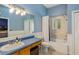 Bathroom with a blue vanity, mirror, vanity lighting, and shower over bath at 830 Miami Springs Dr, Longwood, FL 32779