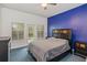 Comfortable bedroom with a blue accent wall, fan, carpet, queen size bed, and access to outdoor balcony at 830 Miami Springs Dr, Longwood, FL 32779