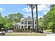 Stately two-story home featuring classic columns, black shutters, an iron fence, and lush landscaping at 830 Miami Springs Dr, Longwood, FL 32779