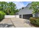 Spacious three-car garage and driveway, complemented by a privacy fence and lush landscaping at 830 Miami Springs Dr, Longwood, FL 32779