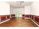 An empty living room featuring hardwood floors, wainscoting and french doors leading to the back yard at 830 Miami Springs Dr, Longwood, FL 32779