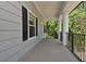 Covered porch showcases elegant columns and black railing overlooking a lush, green landscape at 830 Miami Springs Dr, Longwood, FL 32779